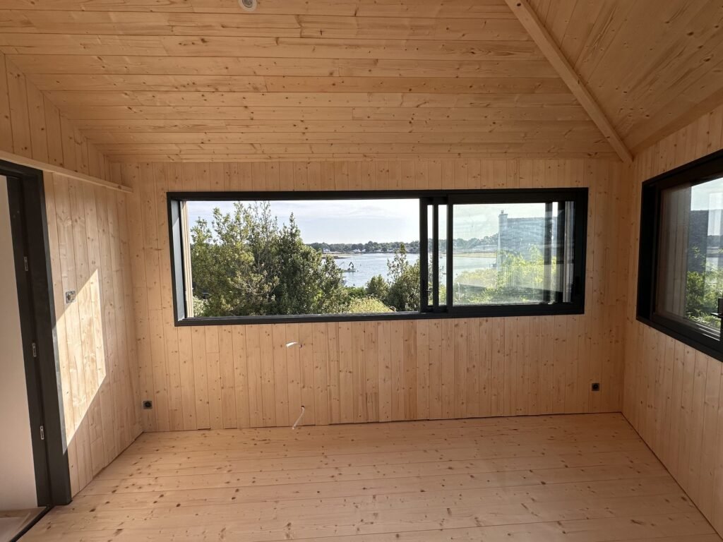 Baie vitrée coulissante en aluminium noir posée sur une extension bois dans le Morbihan