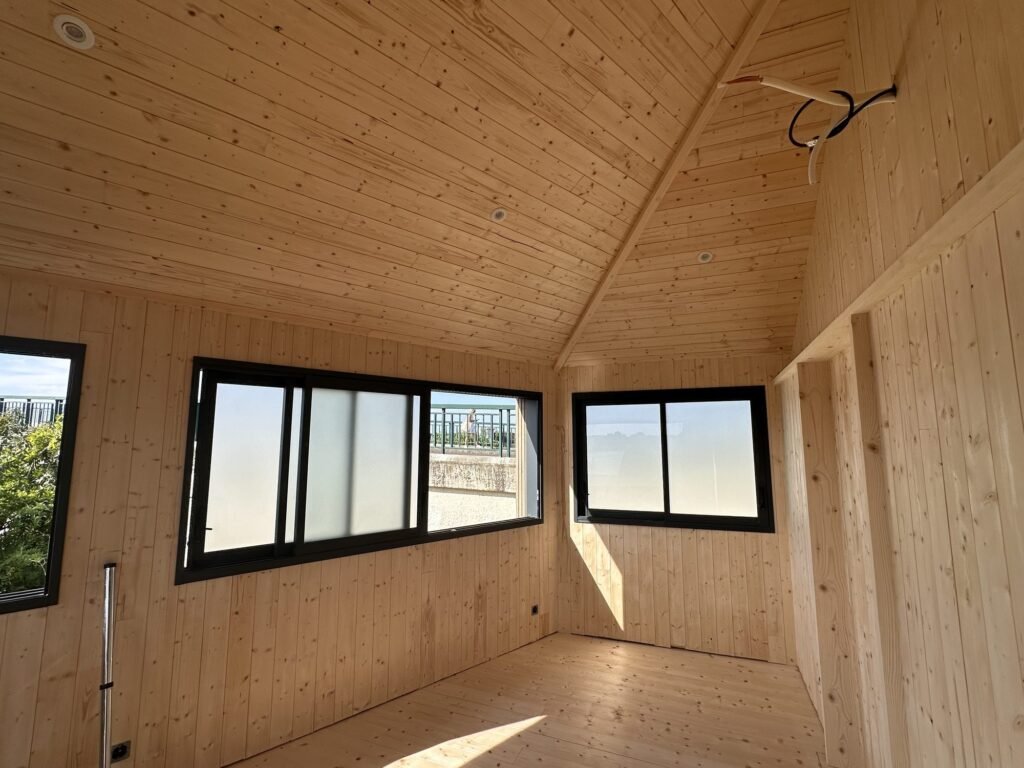Intérieur en lambris épicéa avec fenêtres en aluminium noir dans le Morbihan